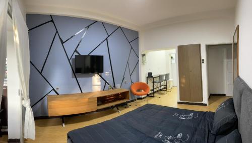 a bedroom with a bed and a tv on a wall at Bat Galim - Mirror Apartment by the beach in Haifa