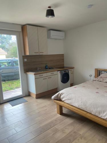 1 dormitorio con 1 cama y cocina con fregadero en Studio proche bordeaux, en Cadaujac