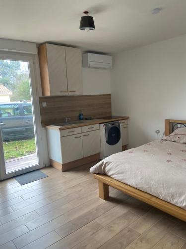sypialnia z łóżkiem oraz kuchnia ze zlewem w obiekcie Studio proche bordeaux w mieście Cadaujac