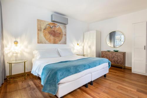sypialnia z dużym łóżkiem i niebieskim kocem w obiekcie Vasari Apartment we Florencji