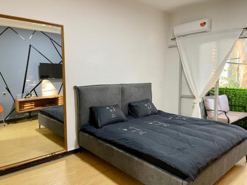 1 dormitorio con 1 cama grande y espejo en Bat Galim - Mirror Apartment by the beach, en Haifa