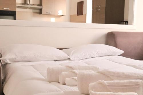 een wit bed met witte lakens en kussens bij Chic and comfortable apartment in Verona in Verona