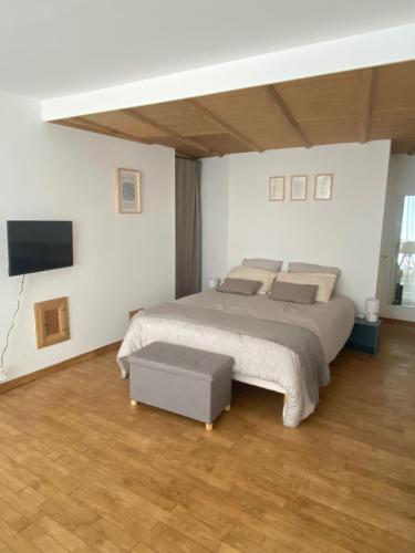 une chambre avec un lit et une télévision à écran plat dans l'établissement La Fontaine de Vinsobres, à Vinsobres