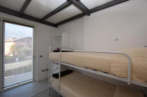 Zimmer mit 2 Etagenbetten und einem Fenster in der Unterkunft Casa Silù - Lago di Como in Colico