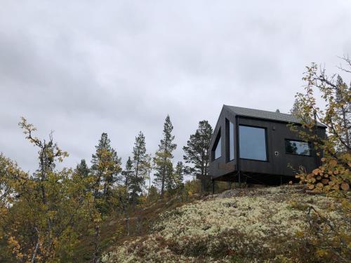 a black tiny house on top of a hill at Baugsberget Fjelltopphytter in Alvdal