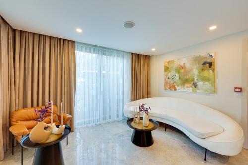 ein Schlafzimmer mit einem großen weißen Bett und einem Sofa in der Unterkunft Bodrum Astrid Hotel in Gümüşlük