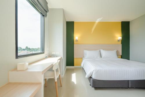 1 dormitorio con cama, escritorio y ventana en พิลโล่ อินน์ ฉะเชิงเทรา Pillow Inn Chachengsao, en Ban Khao Hin Son