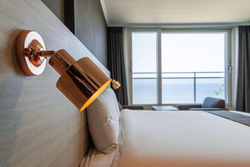 a hotel room with a bed and a window at Gyeongpo Soo Hotel in Gangneung