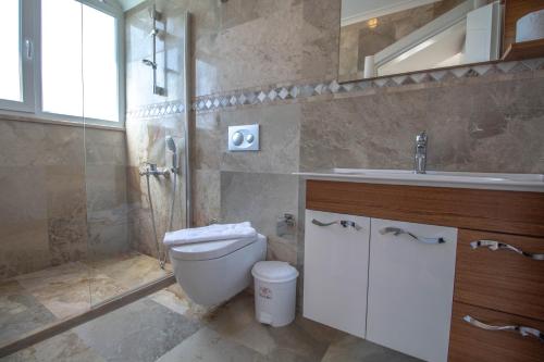 a bathroom with a toilet and a sink and a shower at Hanımeli Villa, Özel Havuzlu, Fethiye in Fethiye