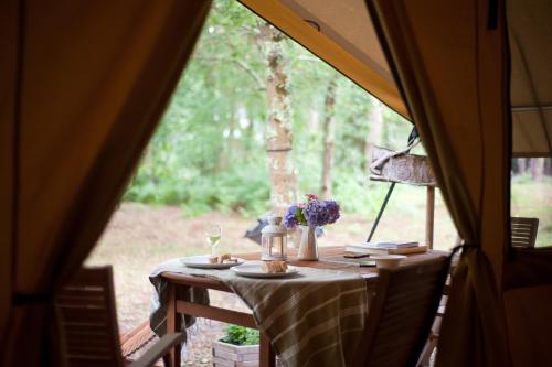 een tafel in een tent met bloemen erop bij Tente Lodge La Téouleyre in Saint-Julien-en-Born