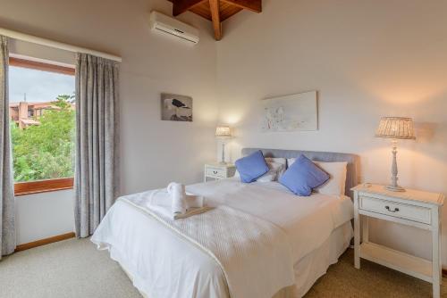 a bedroom with a bed with blue pillows and a window at San Lameer Villa 1939 - 2 Bedroom Classic - 4 pax - San Lameer Rental Agency in Southbroom