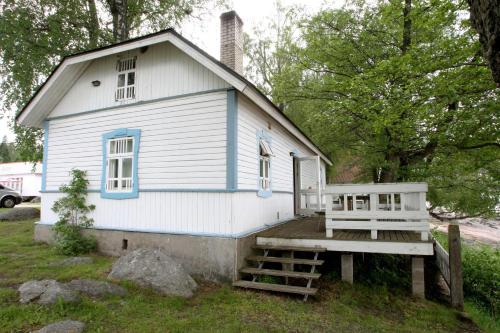 a blue and white house with a porch and a bench at Lainela puhkeküla in Käsmu