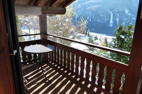 a balcony with a table and a view of the mountains at Ferienhaus Bensel in Alvaneu