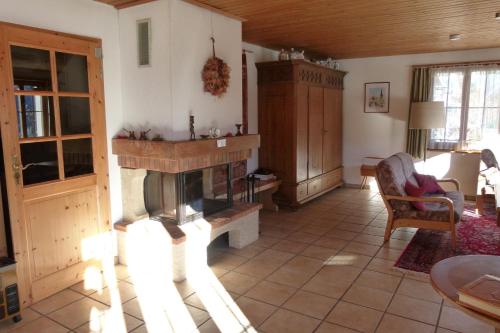 a living room with a fireplace in a house at Ferienhaus Bensel in Alvaneu