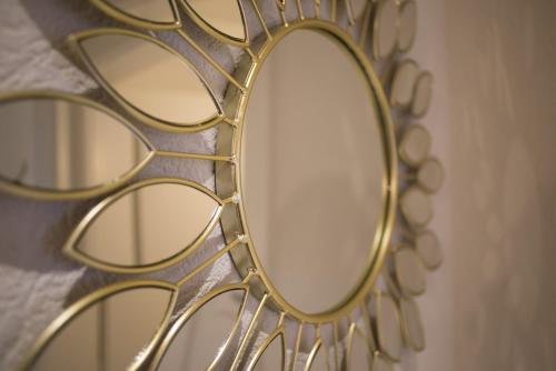 a gold mirror hanging on a wall at Hôtel de la Béroche in Saint Aubin Sauges