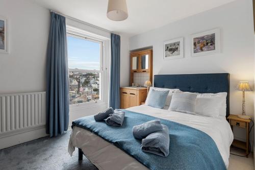 a bedroom with a large bed with towels on it at Polly's Place, Brixham in Brixham