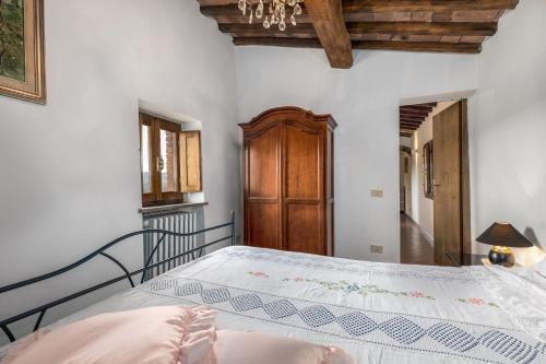 a bedroom with a bed and a wooden cabinet at La Badia in Gambassi Terme
