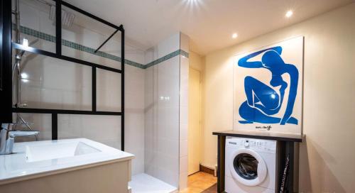 ein Badezimmer mit einer Waschmaschine und einem Waschbecken in der Unterkunft Maison de 3 chambres avec jardin clos et wifi a Moussy in Moussy