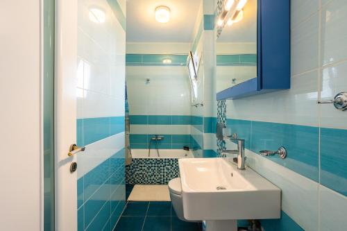 a blue and white bathroom with a sink and a tub at Studio Manolia on the beach in Kalamata