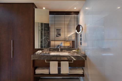 a bathroom with a sink and a mirror at Sea Tower by Isrotel Design in Tel Aviv