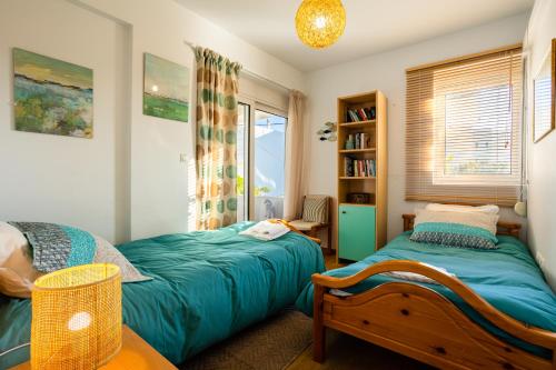 a bedroom with two beds and a window at Studio Manolia on the beach in Kalamata