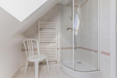a white bathroom with a shower and a white chair at Jolie maison et sa véranda pour de belles vacances in Saint-Philibert