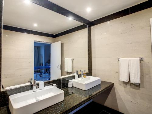 a bathroom with two sinks and a large mirror at Over the Cliff Apartment by LovelyStay in Funchal