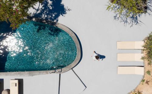 a person on a surfboard in a swimming pool at Madame Kalitsi Cozy Suites in Fira