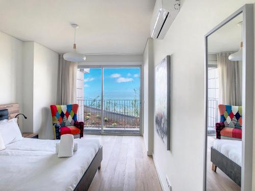 a room with a bed and two chairs and a window at Over the Cliff Apartment by LovelyStay in Funchal