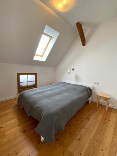 a bedroom with a large bed with a skylight at Wohnen im Grünen in der Nähe von Leipzig in Machern