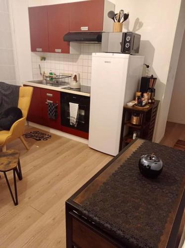 - une cuisine avec un réfrigérateur et une table dans la chambre dans l'établissement Appartement - Nevers, à Nevers