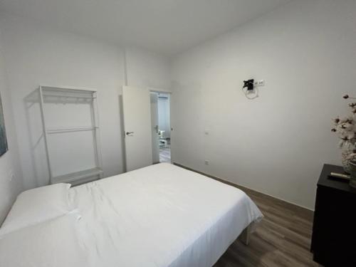 a white bedroom with a large white bed in it at Joju in Sanlúcar la Mayor