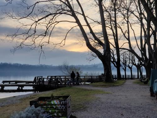 two people walking on a dock near a body of water at Le Tre Arti in Gavirate