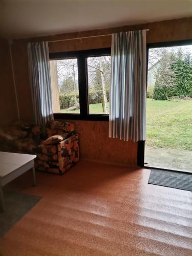 a living room with two large windows and a couch at U Vaclava in Hřensko