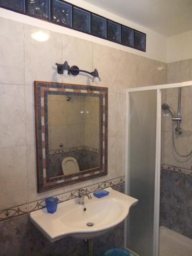 a bathroom with a sink and a shower and a mirror at B&B La Pineta in SantʼAntìoco