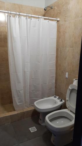 y baño con cortina de ducha blanca y aseo. en Casa MX26 - Los Alisos en San Salvador de Jujuy