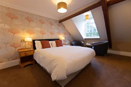 a bedroom with a large white bed and a window at Woodlands Lodge Hotel in Bartley