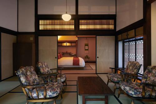a hotel room with a bed and a table and chairs at Shirafuji in Suzaka