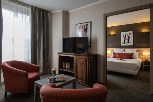 a hotel room with a bed and a mirror at Hotel Amarante Cannes in Cannes