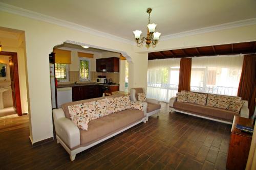 a living room with two couches and a kitchen at Brookland Paris, Özel Havuzlu, Fethiye in Fethiye