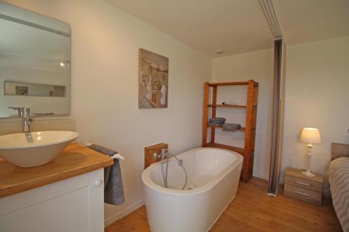 ein Badezimmer mit einer großen Badewanne und einem Waschbecken in der Unterkunft Chez le bayle in Condat-sur-Vienne