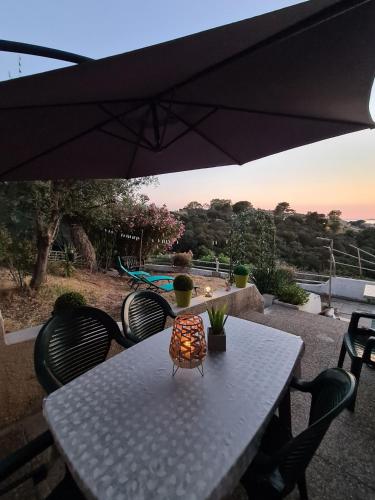 une table blanche avec des chaises et un parasol dans l'établissement PORTICCIO villa dans résidence avec piscines 4-6 personnes BRILOC Appartements, à Porticcio