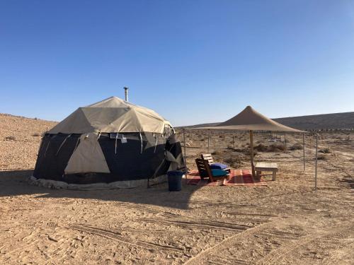 ein Zelt und ein Stuhl in der Wüste in der Unterkunft Skyline eco-camp in Mitzpe Ramon