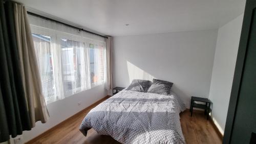 a white bedroom with a bed and a window at Studio - rez-de-chaussée - wifi - télévision in Avesnes-sur-Helpe