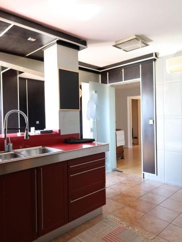 a kitchen with a sink and red counter top at House Prada in Bragança