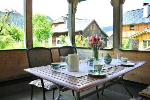 una mesa de madera con un jarrón de flores. en Ferienhaus Archkogl, en Grundlsee