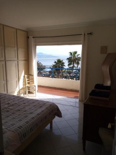 a bedroom with a bed and a view of the ocean at Appartement rooftop vue mer in Antibes
