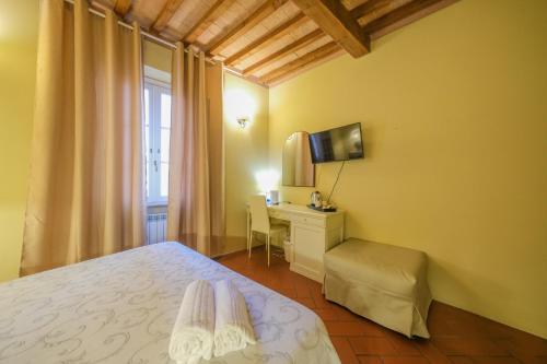 a bedroom with a bed and a desk and a window at San Tommaso in Pisa