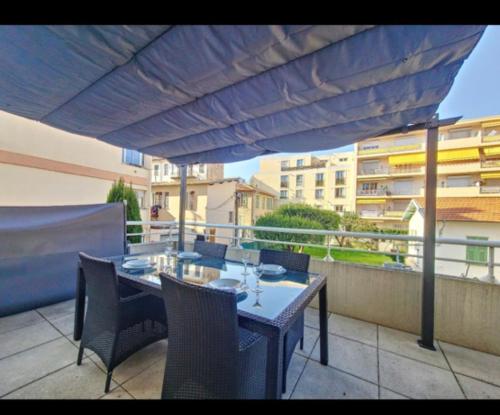 d'une table et de chaises sous un parasol sur le balcon. dans l'établissement Appartement studio, à Nice