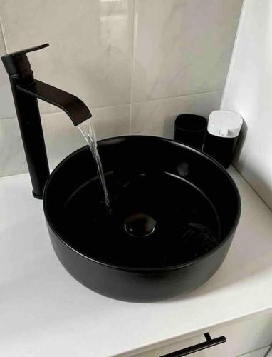 un évier noir avec de l'eau qui en sort dans l'établissement Appartement studio, à Nice